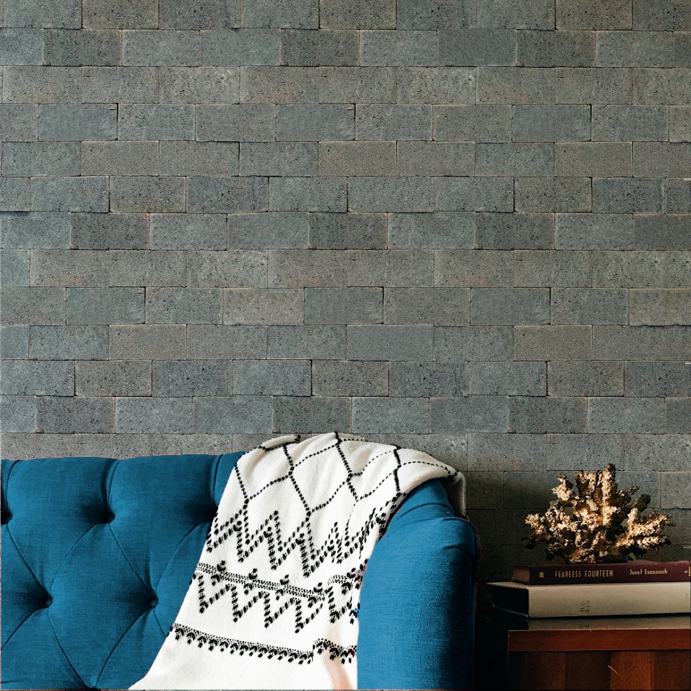 Enchape Gris: muro de ladrillos grises con sillón azul y manta decorativa
