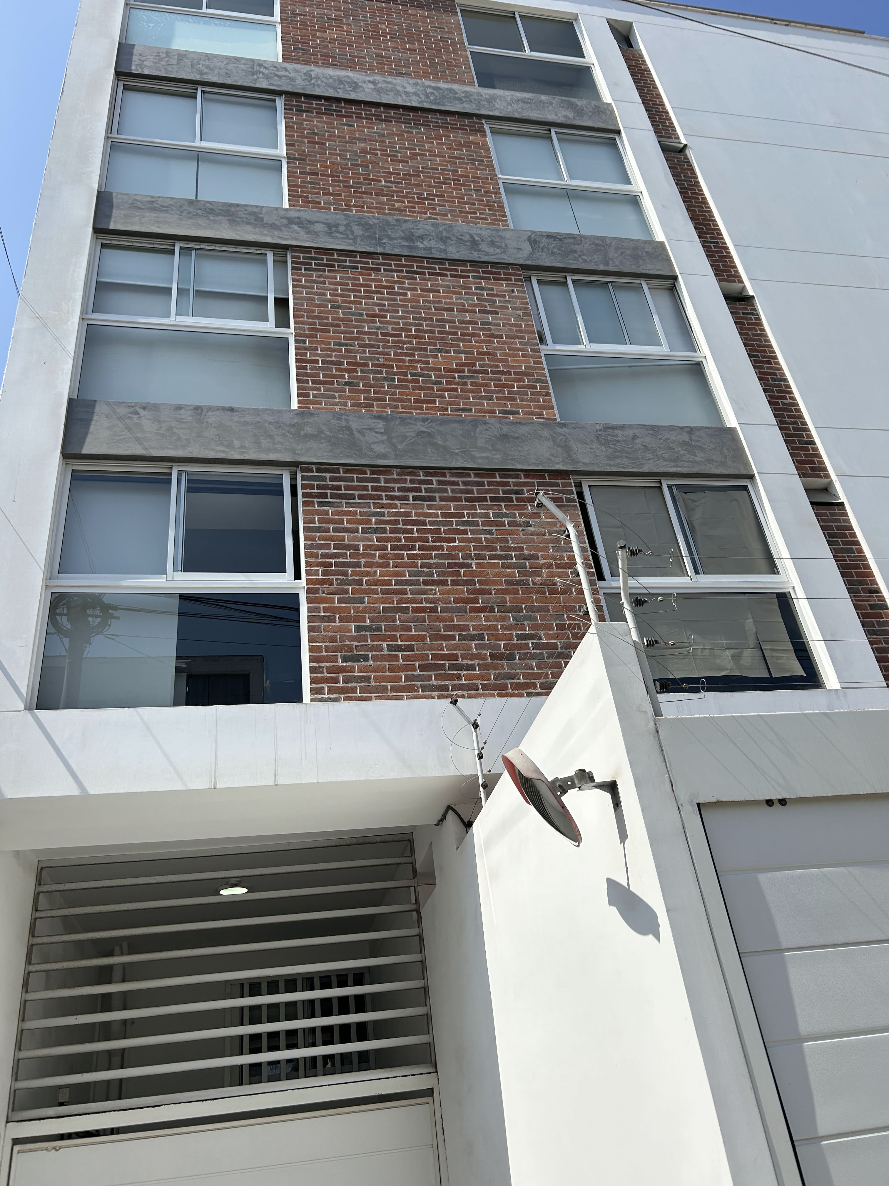 Enchape Hispano: fachada de ladrillo con ventana enrejada