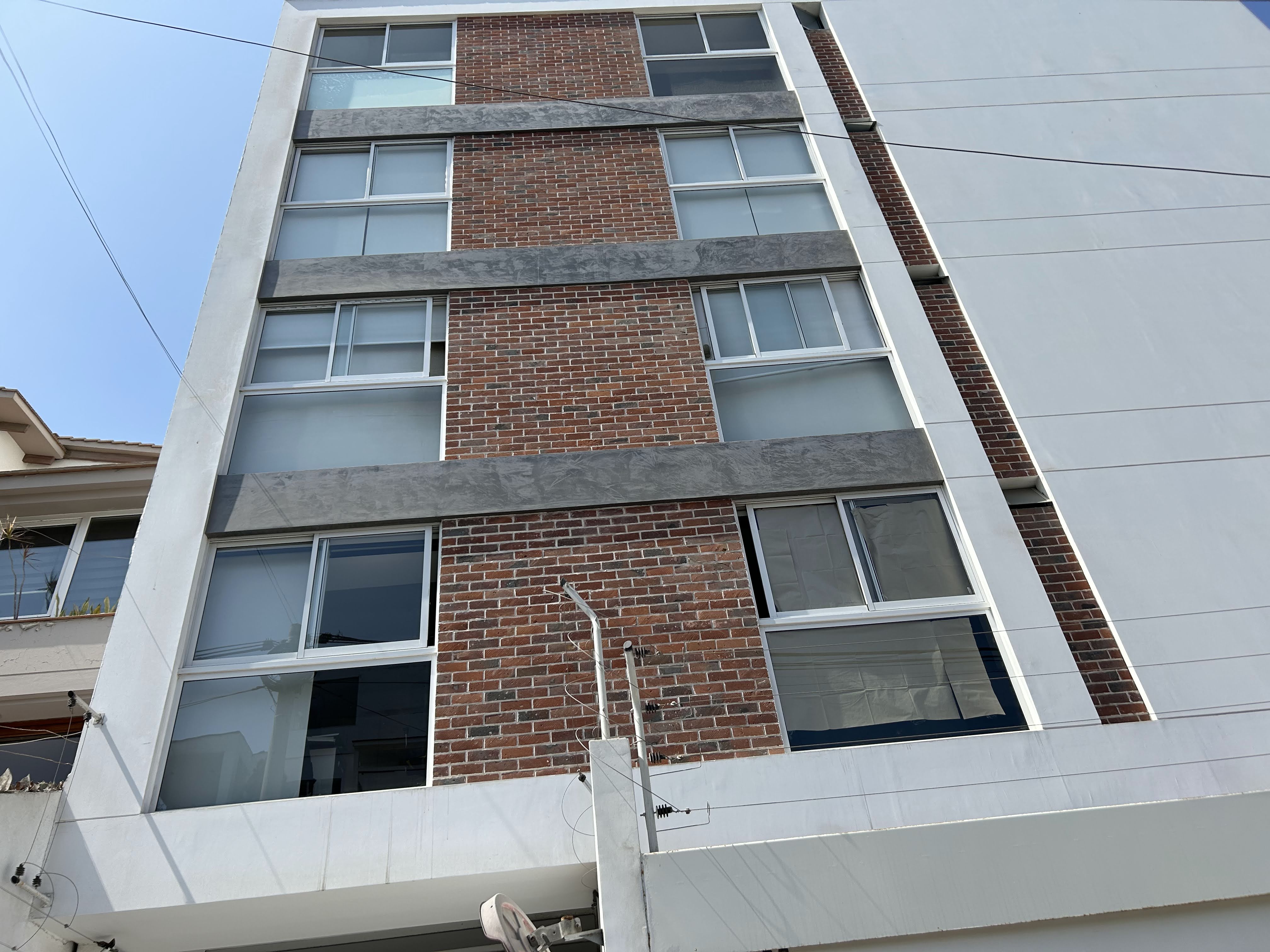 Enchape Hispano: fachada de edificio de ladrillo vista desde abajo