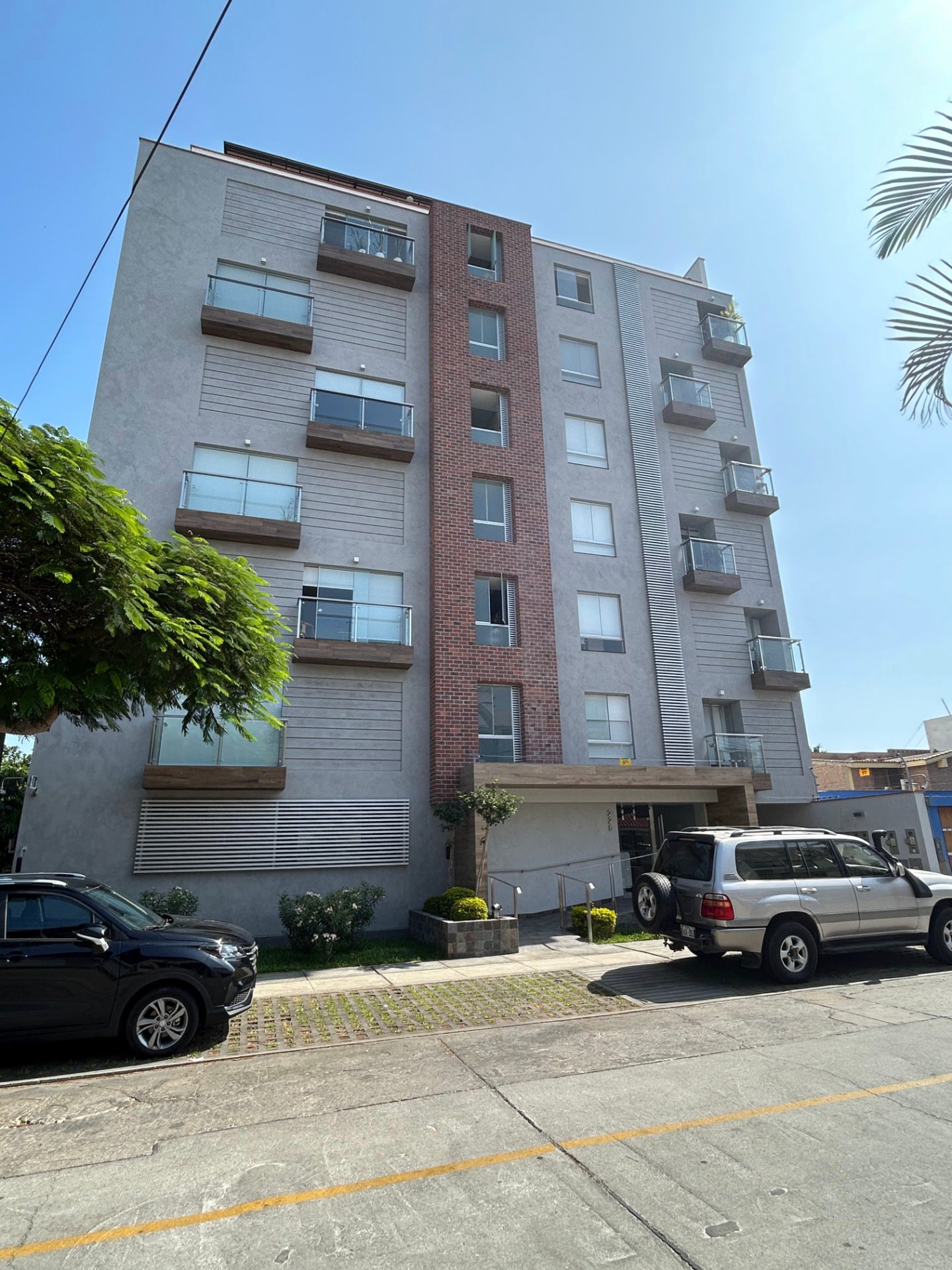 Enchape Hispano: edificio de ladrillo con autos estacionados