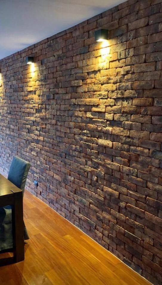 Enchape Antaño: pared interior de ladrillo con apliques de luz cálida