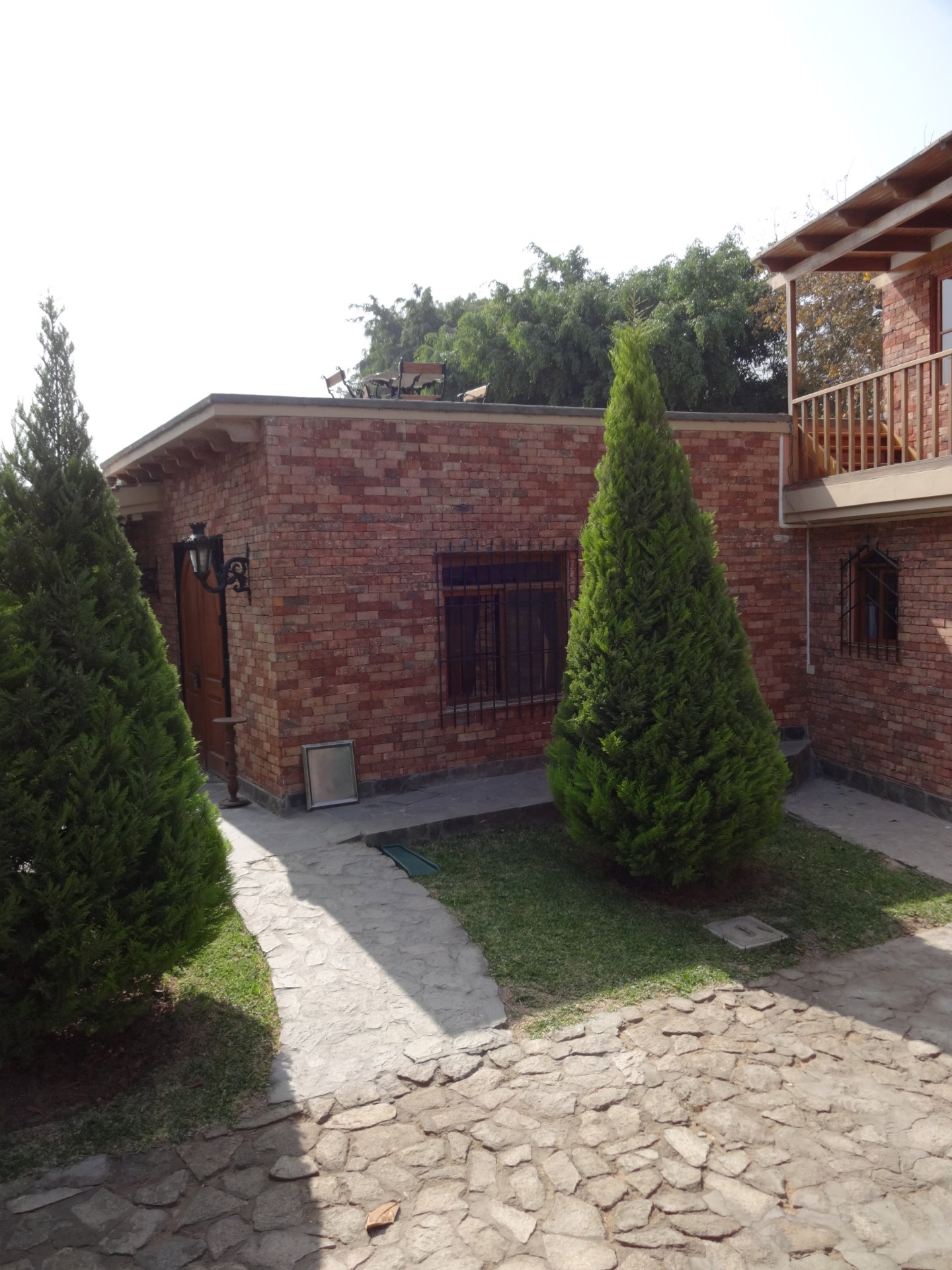 Enchape Antaño: casa de ladrillo con jardín y camino de piedra